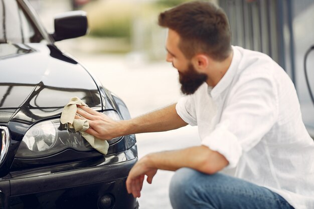 A person wiping the headlights of a car during car detailing services in Irvine