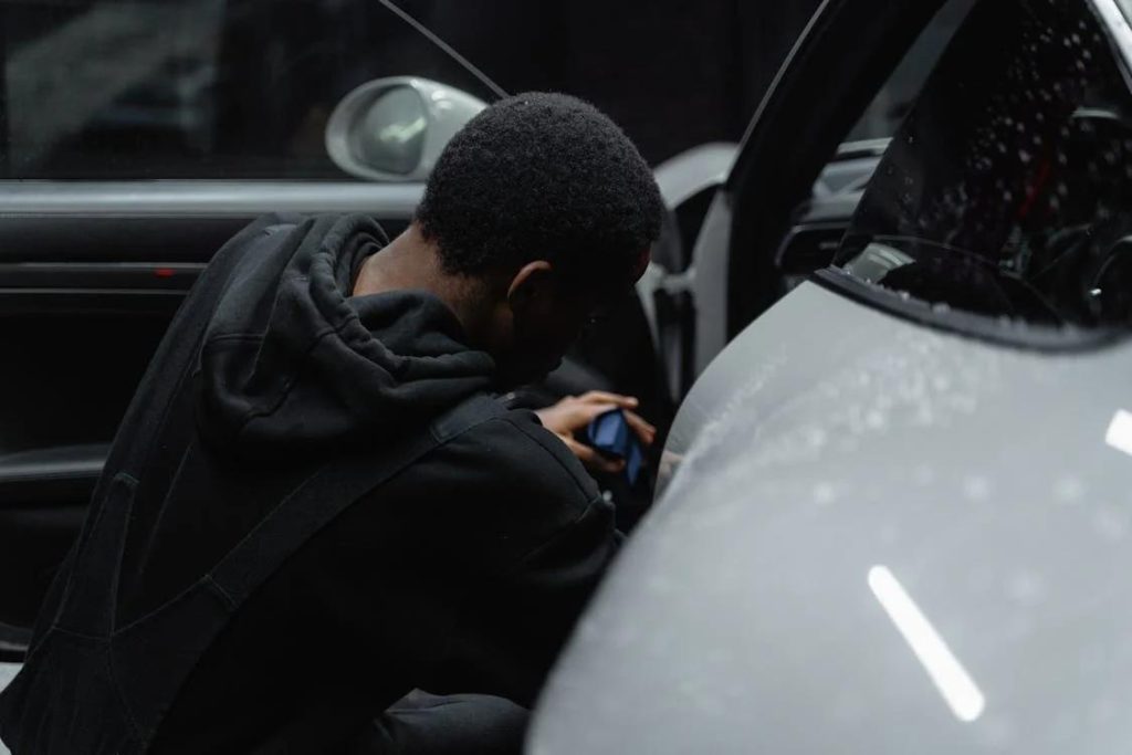 Interior detailing services provider cleaning the inside of a car’s door 