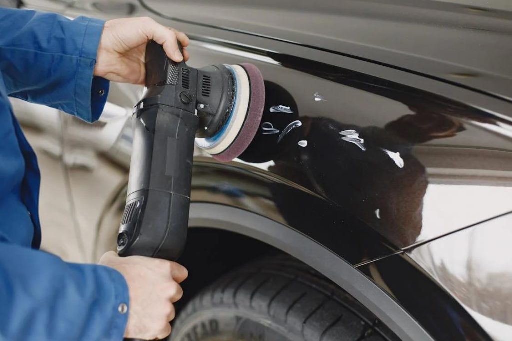 A professional car polishing expert buffing a car
