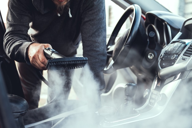 A car getting steam cleaned during a car wash in Irvine