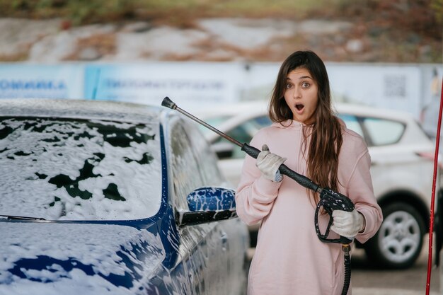 A woman washing a car during auto detailing services in Irvine