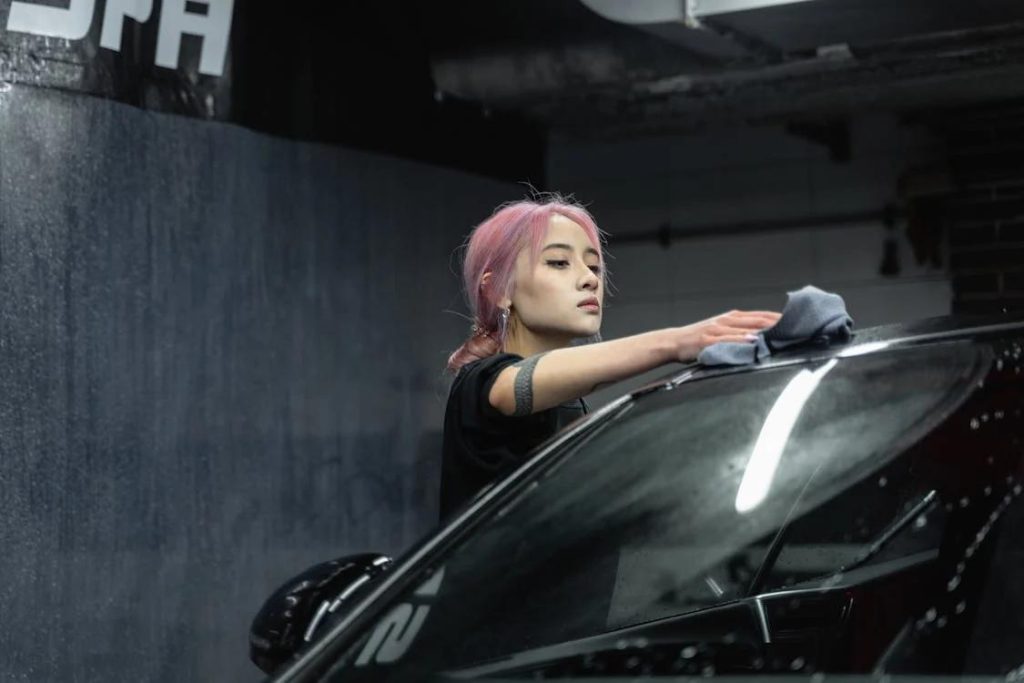 A comprehensive auto detailing expert cleaning a car using a cloth