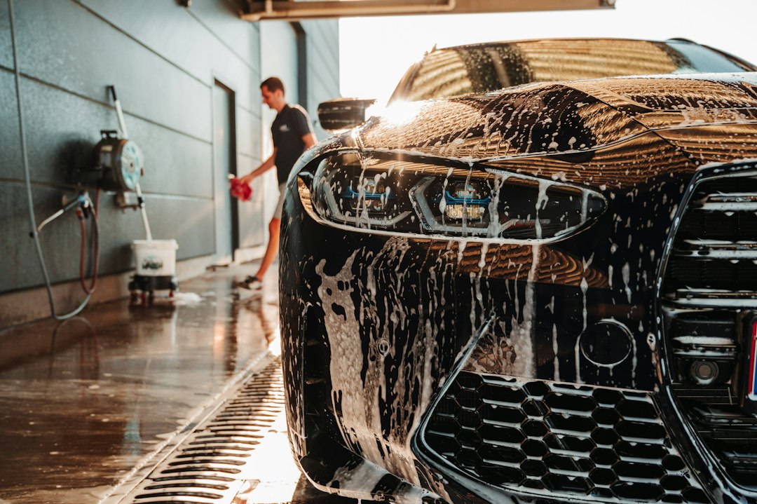 Professional detailer washing a sports car